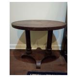 Vintage or antique oval tiger oak library table, twin turned column supports and a shaped lower platform base.