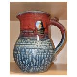 Studio art pottery pitcher with a textured blue/grey base and rust color top. 7.5 in tall.