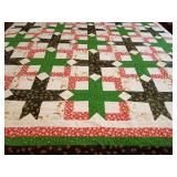 Machine stitched quilt top ready for backing, batting, and quilting. Super Cute Christmas, Snowball Star quilt pattern, festive red and green prints sashed with a cream-and-golden reindeer print fabri