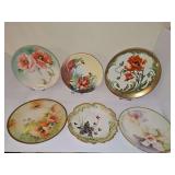 Miscellaneous porcelain plates. Four with wild roses, one with violets, one with orchids. Dimensions 7.75-9 in