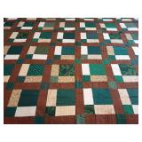Machine stitched quilt top ready for backing, batting, and quilting. Earthy color palette of brown, cream, and varied green prints arranged in a structured block pattern. Approx. 80" x 79".