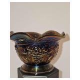 Imperial black (?) carnival glass bowl featuring a textured grape and vine pattern with an iridescent, ruffled rim. 5x 3.25 in tall.