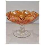 Iridescent marigold carnival glass footed candy dish with a ruffled edge. 5.75 x 4 in tall. Sticker residue on underside of foot as shown.