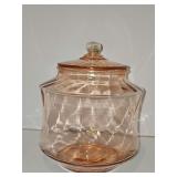 Pink depression glass cookie or cracker jar. 9 in tall. Some air bubbles are visible indicating age.  Inside rim has some flea bites and small chips.