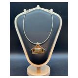 Statement pendant necklace featuring a manger design set on a snake chain - pendant can also be worn as a brooch