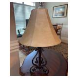 Decorative rustic, hand-forged wrought iron table lamp featuring a scrolled tri-leg base and a warm, parchment-style empire or hexagonal faux-leather shade - 18” tall