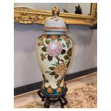 Decorative hand-painted porcelain or ceramic lidded ginger jar/temple jar with a cream or crackle-glaze background and colorful floral, foliage and butterfly motifs sitting on wood stand - 15 tall inc