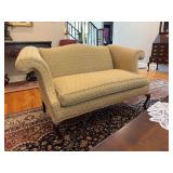Chippendale-Style Camelback Loveseat with a curved back, rolled arms, patterned yellow/gold upholstery, and carved wooden legs