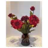 Vintage-style decorative centerpiece featuring a brown/amber art glass vessel set inside a dark metal or iron wire cage with leaf accents and artificial florals