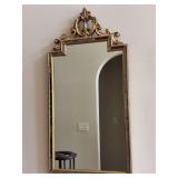 Ornate gold-gilt wall mirror with a distinct decorative pediment at the top, styled in a classic Rococo - 22 x 43-3/4