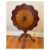 Stunning Georgian Revival Tilt-Top Table with a scalloped pie-crust edge, a sunburst-veneered top, a turned pedestal, and a tripod base - 26”D x 26” tall