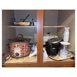 Contents of kitchen cabinet - crock pot, electric skillet, electric emulsifier, handheld cheese graters and more