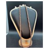 Long strand of Worthington brushed satin finish pearl-like necklace