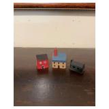 Two miniature primitive style wooden houses and a metal log cabin