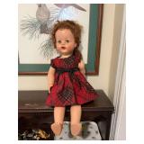 Vintage mid-century, hard plastic, Saucy  Walker, baby doll in plaid dress. Left arm needs repair. 24 inches.