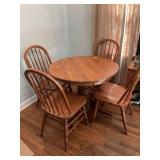 Solid oak dining room table with one leaf and four chairs. Table is 36 inches round by 30 inches tall width and 9 3/8 inch leaf.