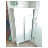 Cute vintage white two door cabinet. 27“ x 12“ x 54“.. contents not included. The door does close all the way it just has a bowl blocking it from shutting at this moment.