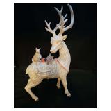 Frosted wood look holiday reindeer with featuring a squirrel, a red cardinal, and a small rabbit resting on its back. 8.5 x 3 x 16 in tall.