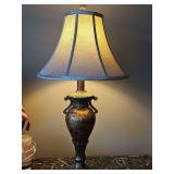 Traditional-style Urn Table Lamp with a distressed bronze/gold finish and a flared fabric shade. 28 in tall.