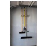 Lot Of Brooms And Scraper Hanging On Wall
