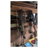 Lot of bar clamps hanging on lumber rack