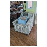 swivel living room chair with pillows and blanket
