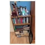 bookshelf with books and small quilt top on wall