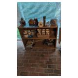 bookcase with coffee mugs, oil lamp, candles and