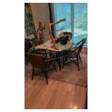 glass top dining table with four woven armchairs