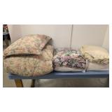 lot of bedspreads and comforters