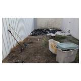 plastic storage boxes tomato cages rake and fork