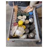 Assorted Spray Paint Cans, Wood Trim Pieces, and Dust Masks in Plastic Crate