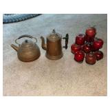 Brass tea and coffee pots.  Wooden apples on metal rack.