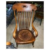 Antique wooden rocking chair with leather seat insert.