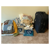 Household linens and Samsonite roller suitcase