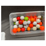 Golf balls and practice balls in shoebox tote.