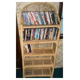 Folding wicker shelf, 22" W x 10" D x 55" T with DVDs, not all cases may be full