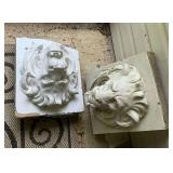 Pair of concrete lion heads, one is broken