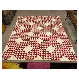 Red and white hand quilted quilt, shows wear