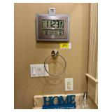 Lot of Home Decor Including Atomic Clock, AcuRite Digital Thermometer, Decorative 'Home' Sign, Glass Diffuser Bottle, and Brushed Nickel Towel Ring