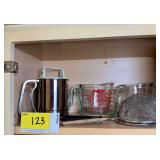 Kitchen Utensil Lot Featuring Pyrex Measuring Cups, Sifter, Grater, and Strainer