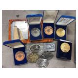 Four NRA medals, 5 belt buckles and a case length measure