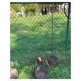 Metal yard art includes 2 mole traps, two kettles (one missing its bottom), 20” steel wheel