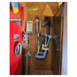 Items on pegboard include nail belt, chain hooks, saws, rope, window squeegee, face shield, C clamps