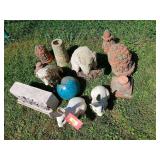 Yard art in varying condition includes cement dog and a pretty blue bowling ball