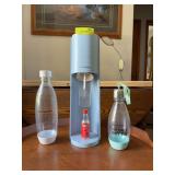 Soda Stream machine, four bottles and a bottle of bubly drops