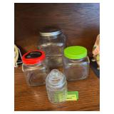 Three clear glass jars and basket pattern candy jar