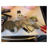 Vintage kitchen items includes sifter, chopper, scoops and a fork