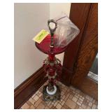 Approx 32” tall red glass ashtray w red prisms and cherub base