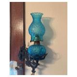 Cast iron wall bracket with blue glass daisy and button oil lamp
